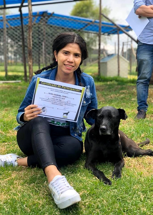 Voluntaria de Arca Luminosa junto a un perro rescatado, con certificado de participación en jornada de la fundación